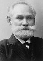 Photo of Ivan Pavlov in his older years, with a white beard, wearing a suit and tie.