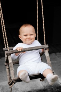 smiling baby in a swing