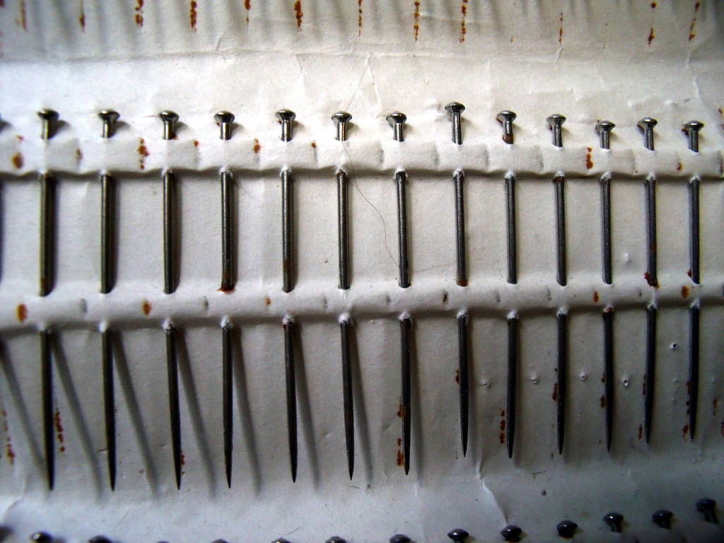 Card full of old pins, in a row.