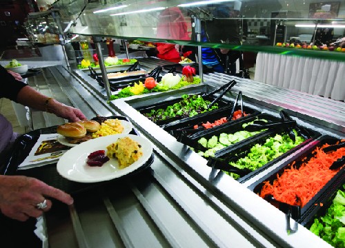 Photo of food at a cafeteria with glass shielding over the food.