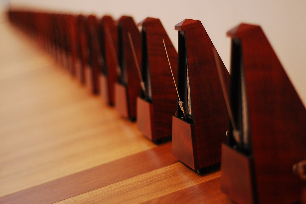 Photo of a row of wooden metronomes.