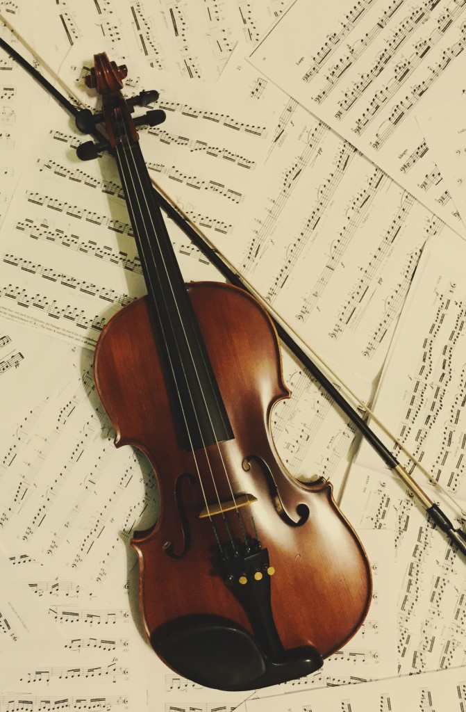 Photo of a violin lying on sheet music.