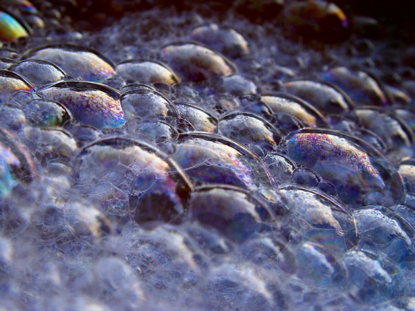 Soap bubbles reflecting mostly purple and blue light with some regions of orange.