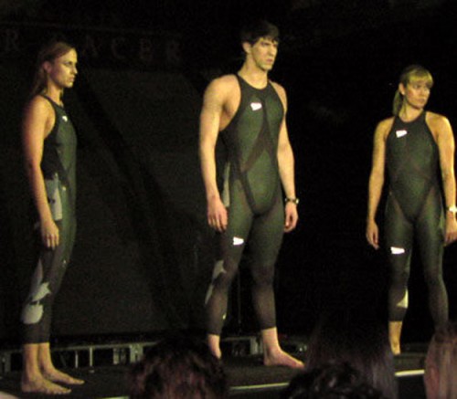 Three swimmers each wearing an L Z R Racer Suit, which is a swimsuit composed of elastane nylon and polyurethane. The seams of the suit are ultrasonically welded to reduce drag.