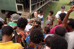 U.S. soldier distributing handouts explaining symptoms of tuberculosis to local residents at Bunabun Health Center in Madang, Papua New Guinea.