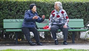 Two people having a conversation on a bench.