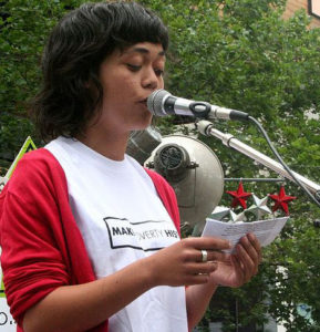 A woman reading a speech at a microphone