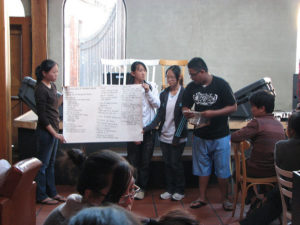 Four students with a poster and a microphone