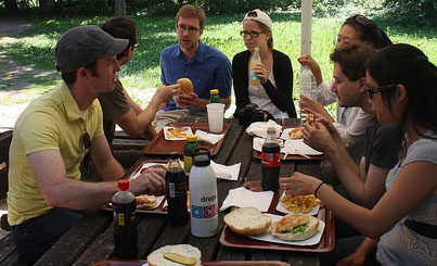 A group of people at a picnic table eating food