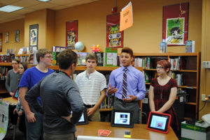 Four students giving a presentation in a library