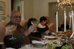 People sitting at a dinner table, holding their glasses in a toast