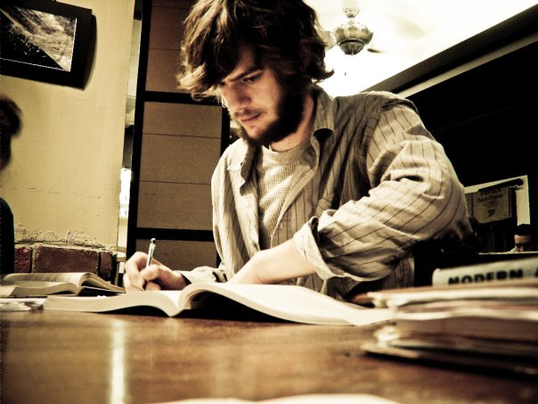 Photo of a guy doing homework on a table