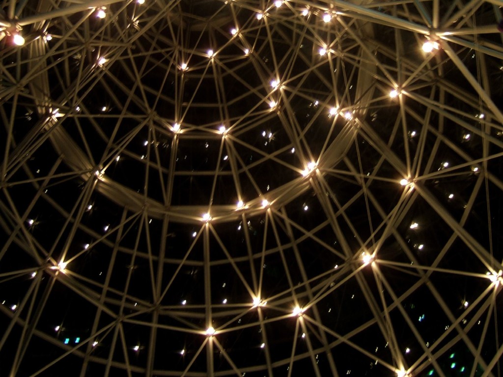 Photo at night of a monkey-bar-like structure with lights on it—resembles a constellation of stars.