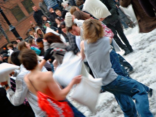 People having a pillow fight outdoors are shown here.