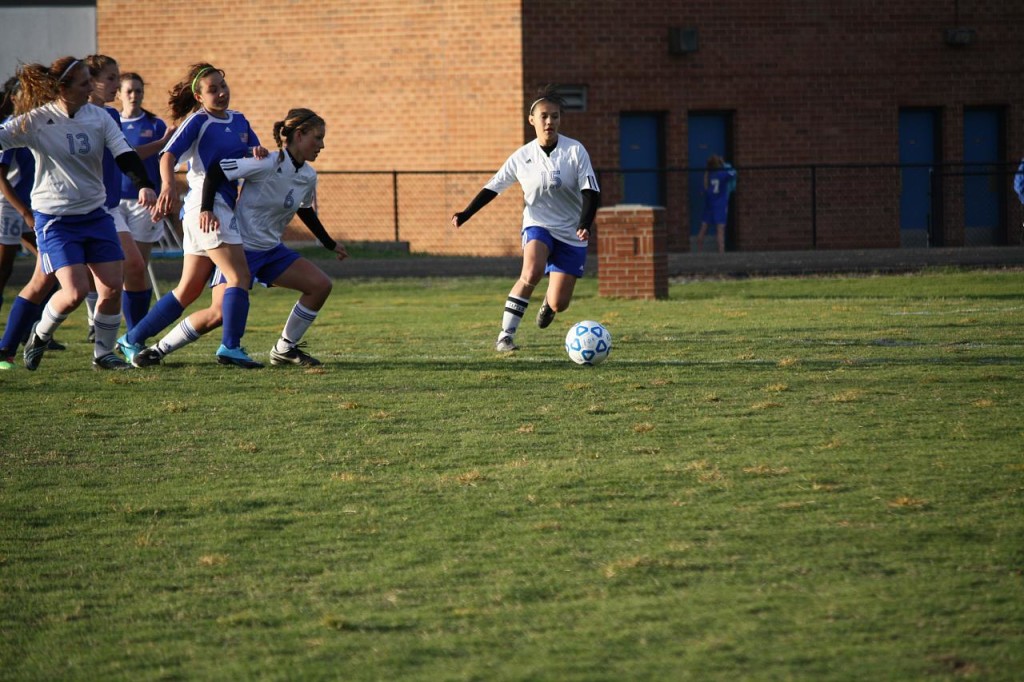 Photo of girls playing soccer on a school field