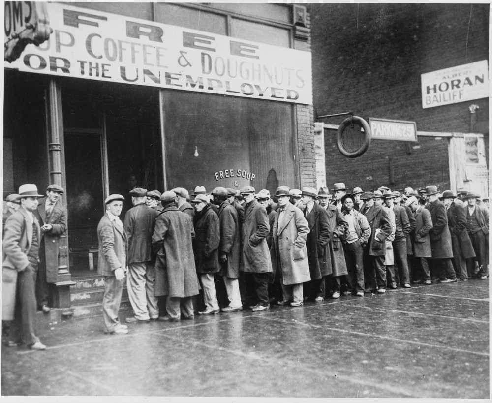 A line of men in front of a building that advertises free soup.