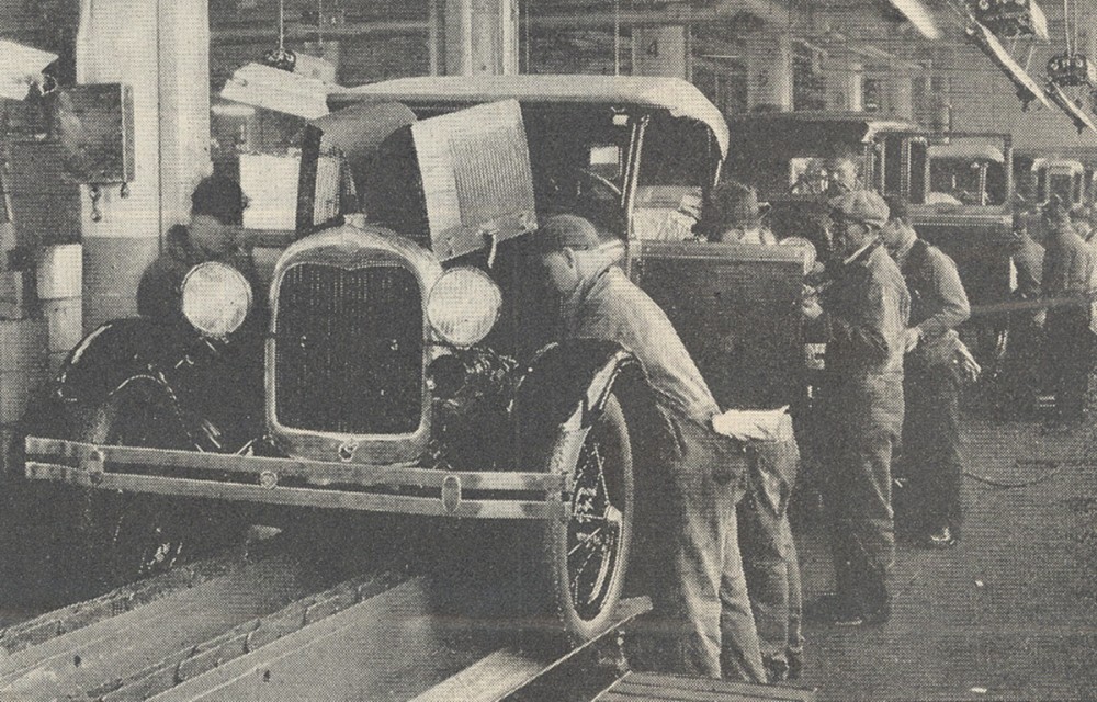 Men positioned along an assembly line for Ford automobiles.