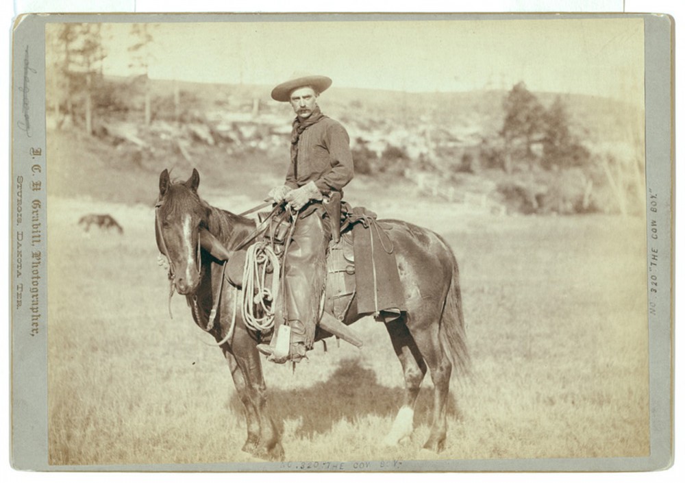 A photograph of cowboy on a horse.