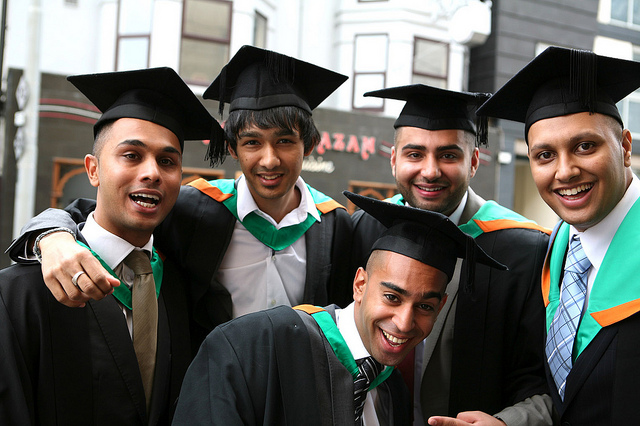 Five young men in graduation gowns
