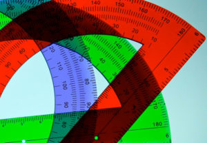 Three overlaid plastic protractors in red, green, and blue