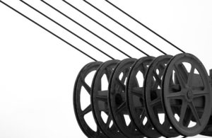 Black and white photo of six power line cables on reels