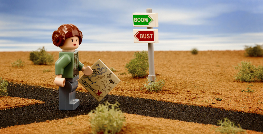 Photo of a Lego woman holding a map, standing at a crossroads labeled 