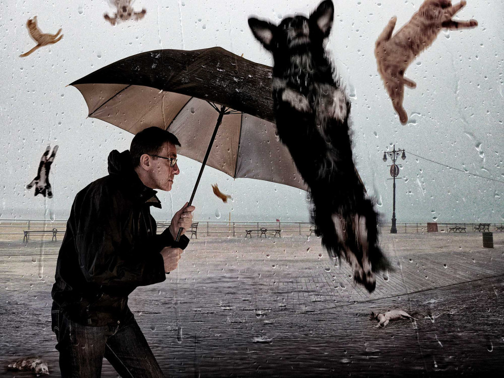 A man hiding under an umbrella from the cats and dogs raining from the sky.