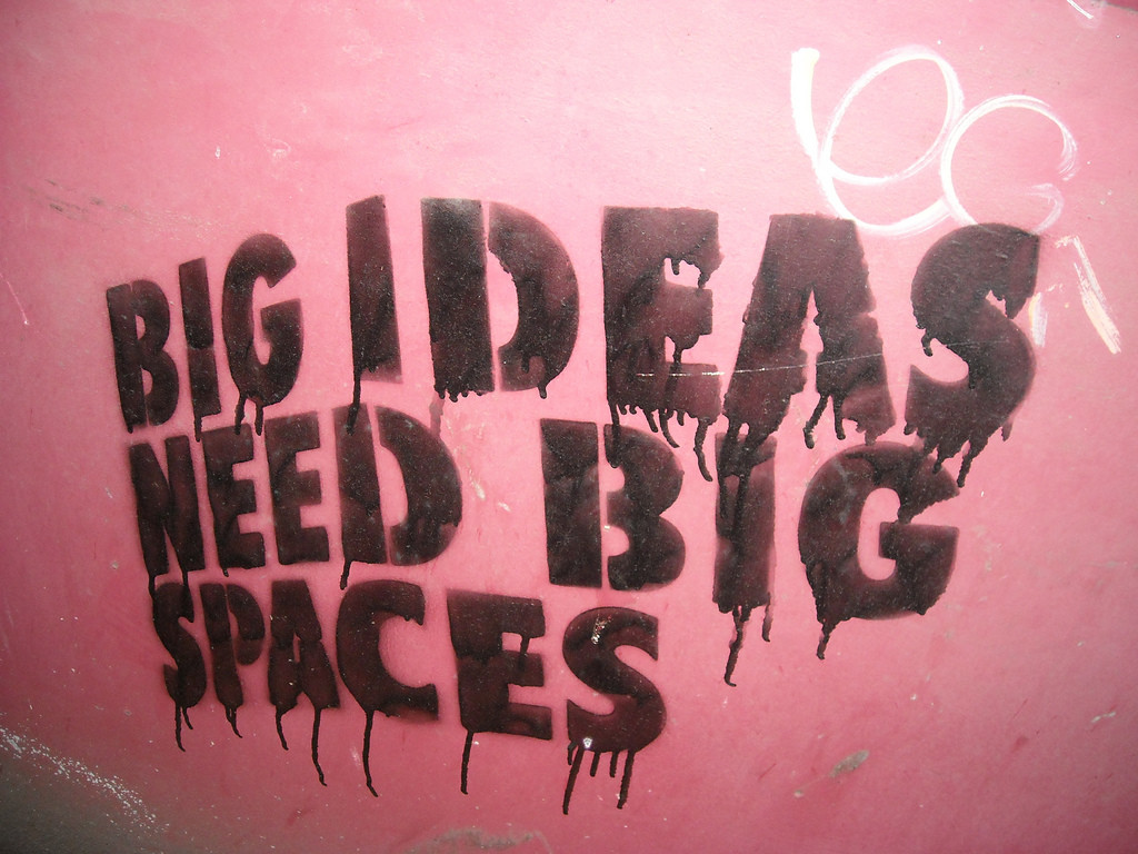 Pink wall with black block letters that read, BIG IDEAS NEED BIG SPACES.