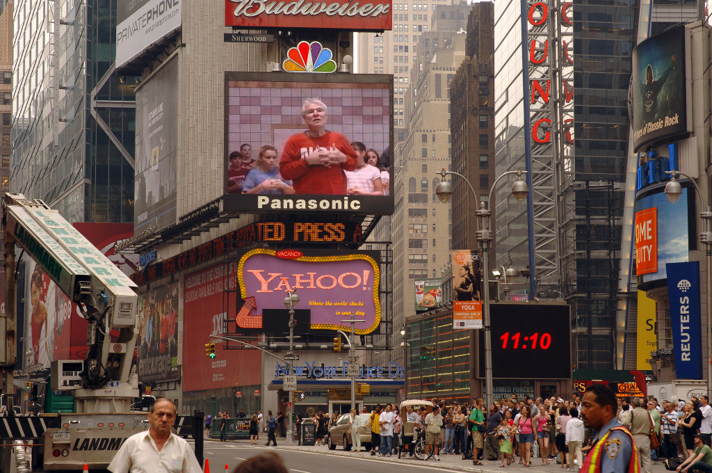 Photo of Times Square in New York City. At center are two large, lighted billboards advertising Panasonic and Yahoo.