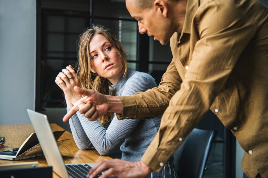 A man speaking to a woman, who is focused on listening.