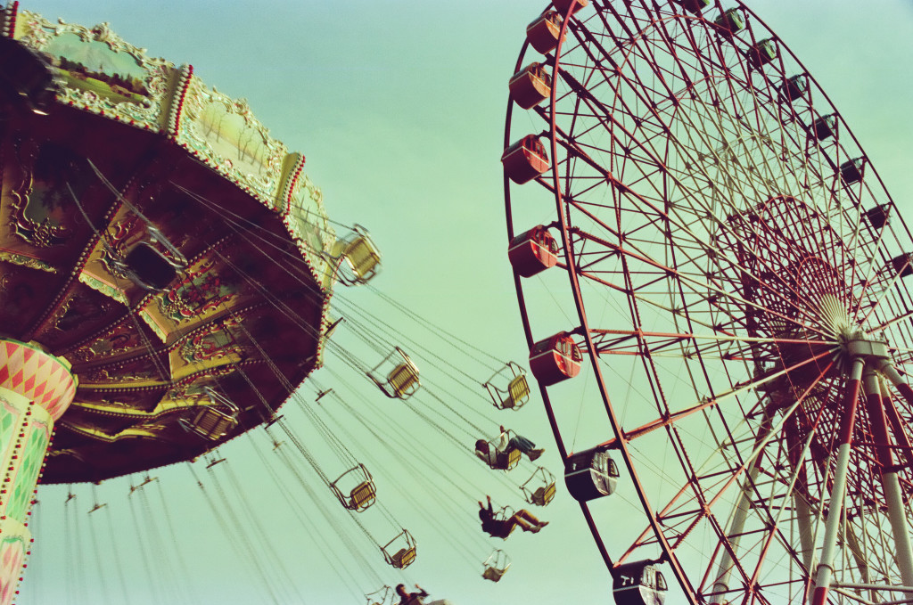 Color photo of a carrousel and a ferris wheel.