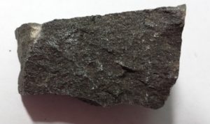 A dark gray, rough-textured mineral