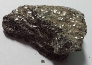 A dark mineral with white flecks