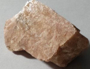 This mineral is not shiny, does not appear to have any streaks, and is a light brownish pink