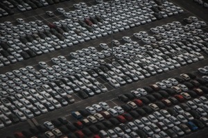 Photo of a large dealership parking lot with hundreds of cars parked in neat rows.
