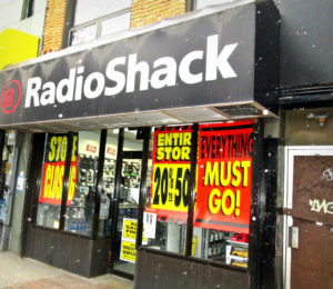 Photo of Radio Shack store going out of business. Storefront covered with signs that read, 