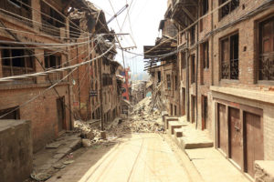 Photo street in Nepal after 2015 earthquake. The end of the road is impassable due to fallen bricks and debris from buildings.