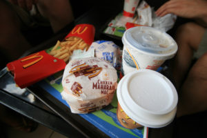 Photo of a plastic food tray with McDonald's fries, two drinks, a regular burger, and a chicken 