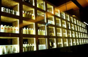 Rows of fancy hair products shown on backlit glass shelves.