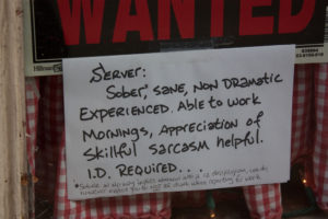 Photo of a Help Wanted sign that reads, 