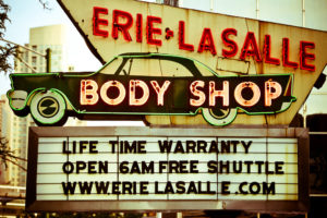 Photo of neon sign for Erie LaSalle Body Shop. The marquee reads, 