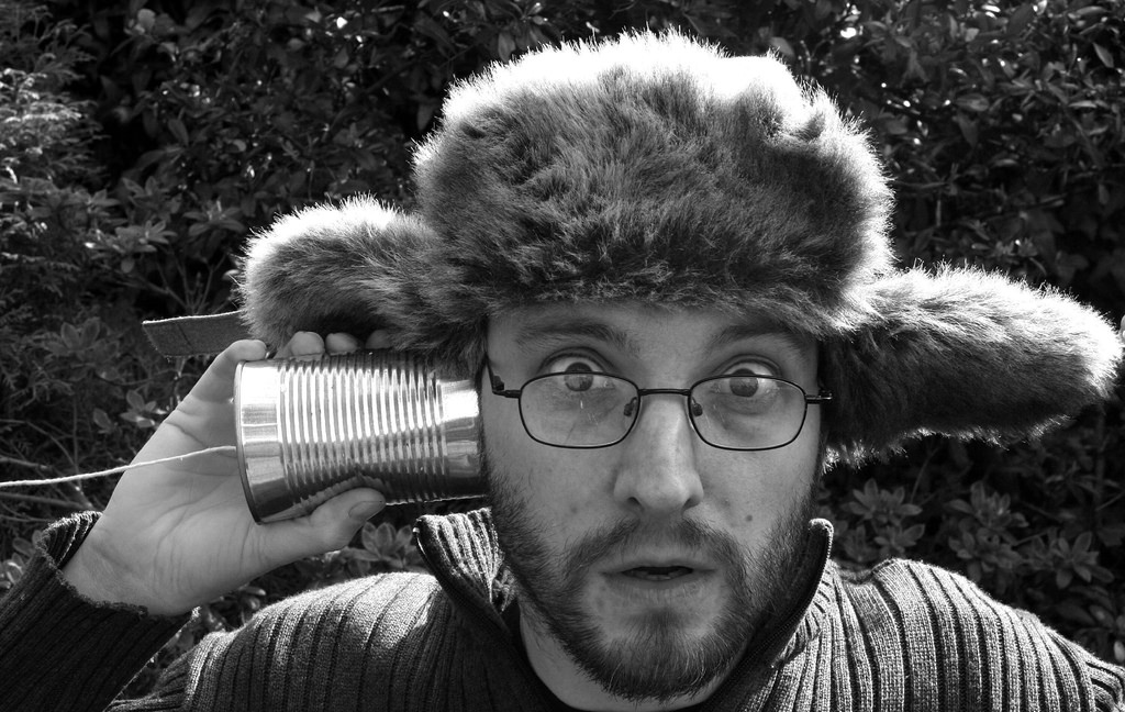 Humorous photo of a guy in a beaver hat holding a soup-can 