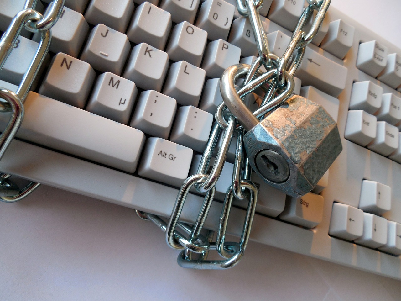 Photo showing a computer keyboard with a chain and padlock wrapped around it