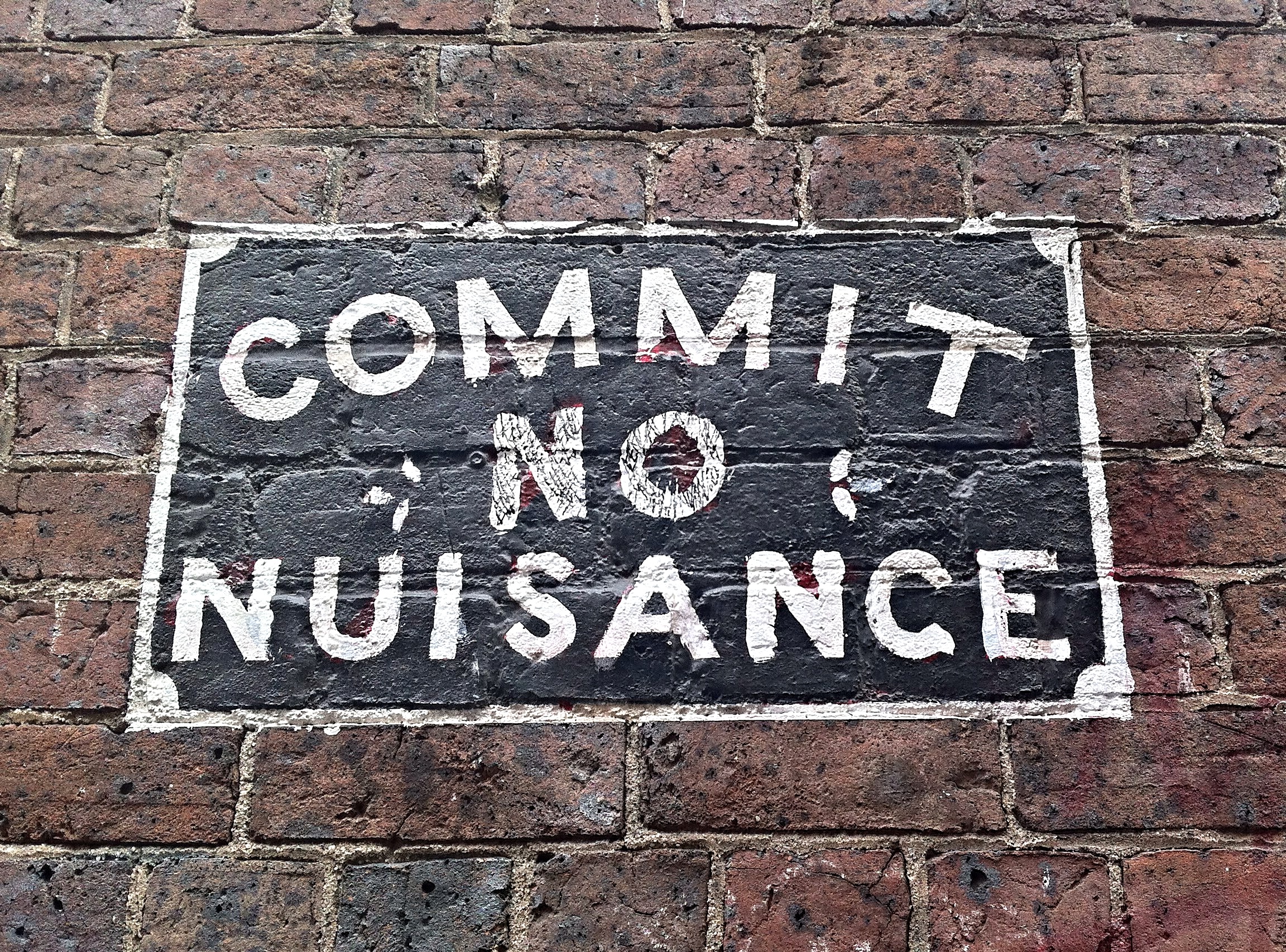 Australian sign on a brick wall that reads, 