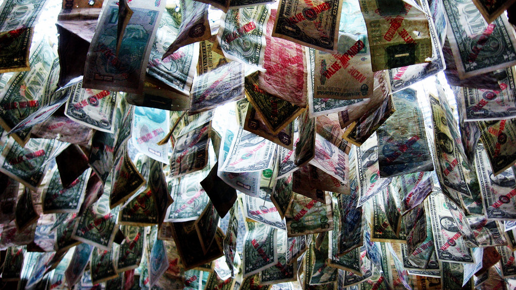 Photo of many different kinds of currency hanging from a ceiling.