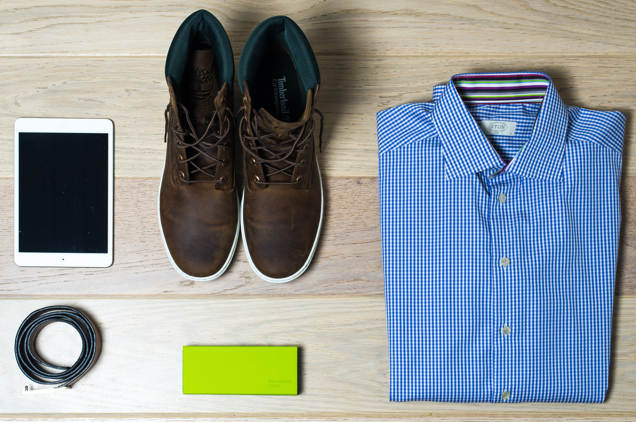 Photo of products: a pair of men's shoes, a folded blue men's shirt, an iPad.