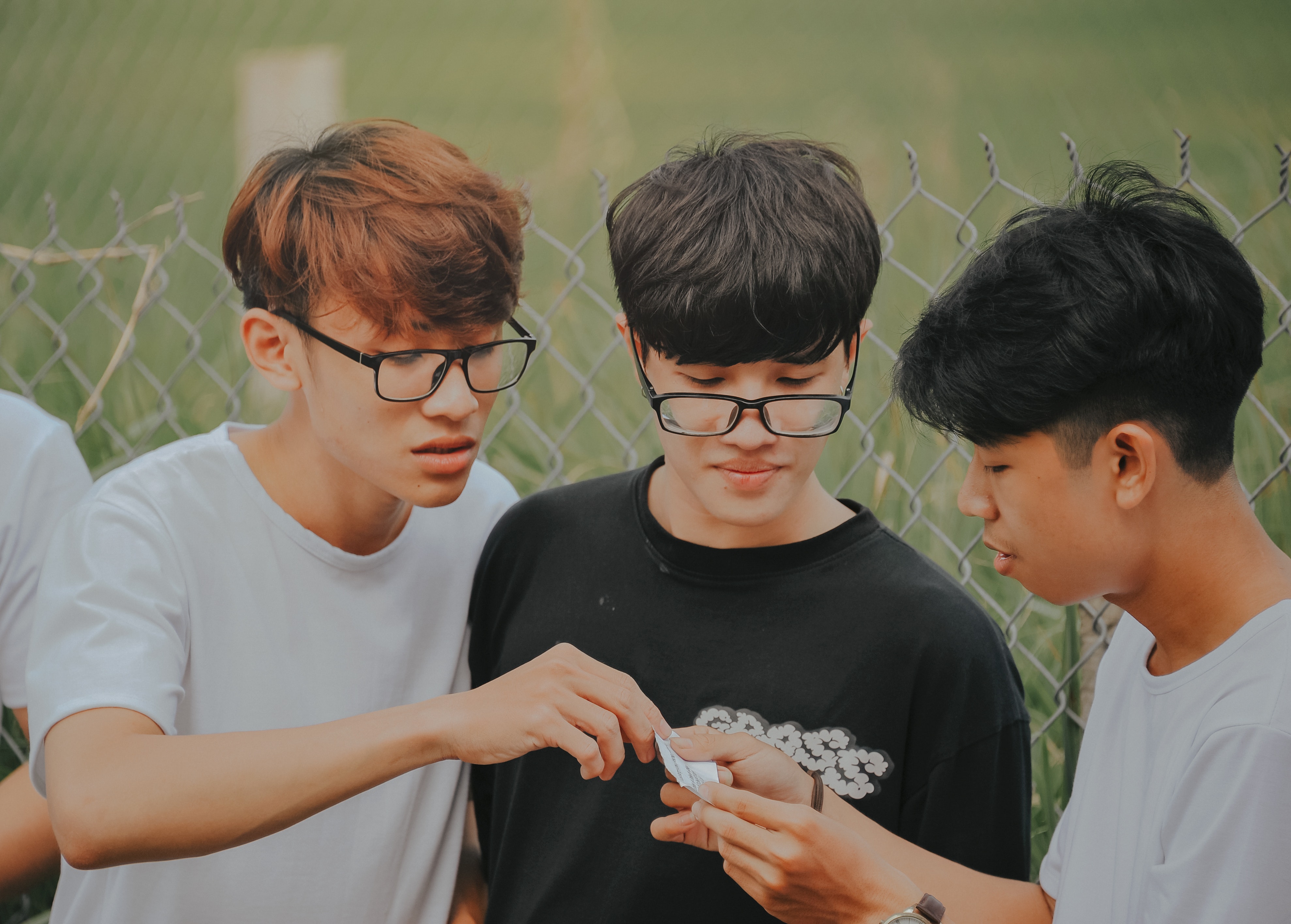 three boys look at a note together