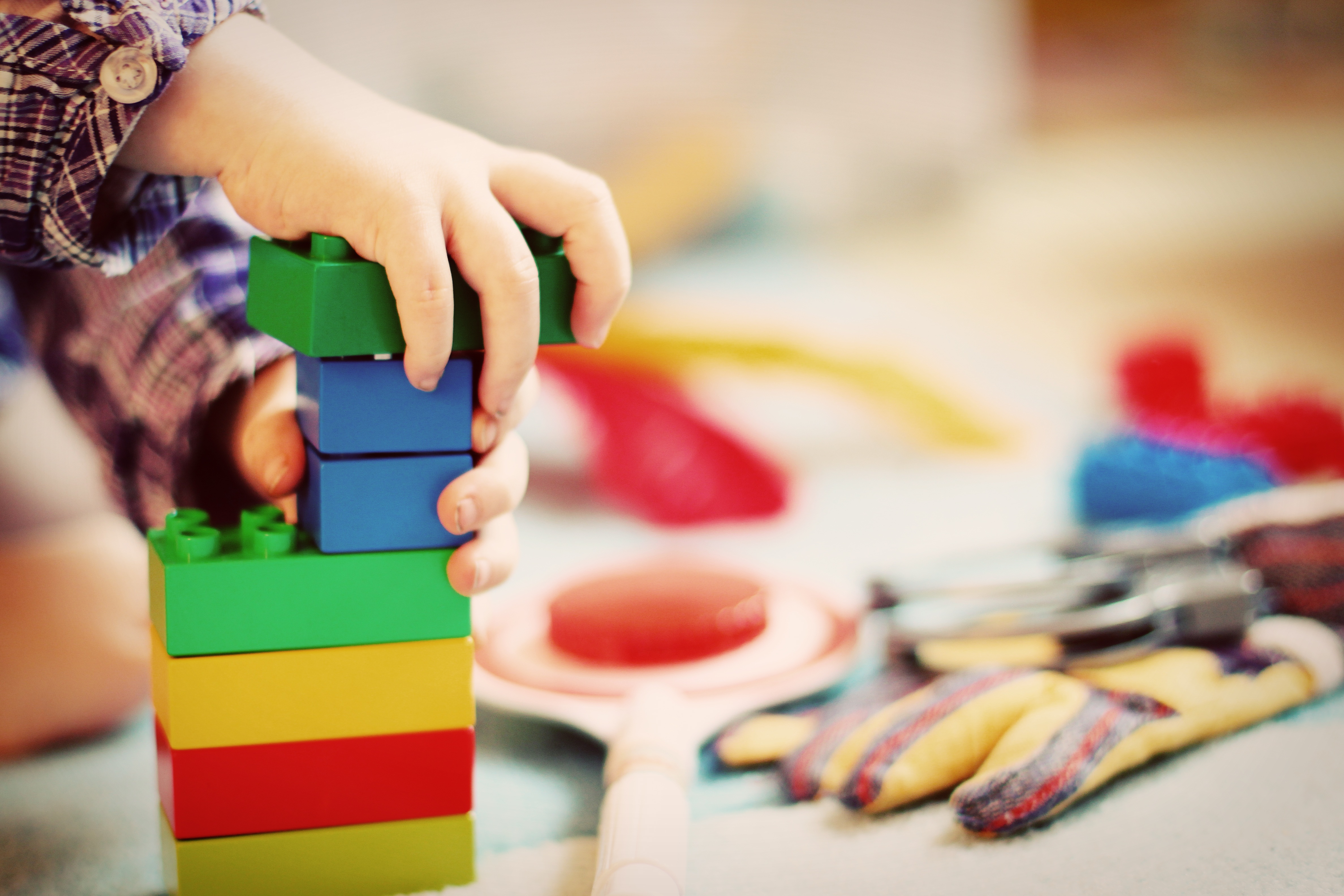 A toddler building a tower out of colorful blocks