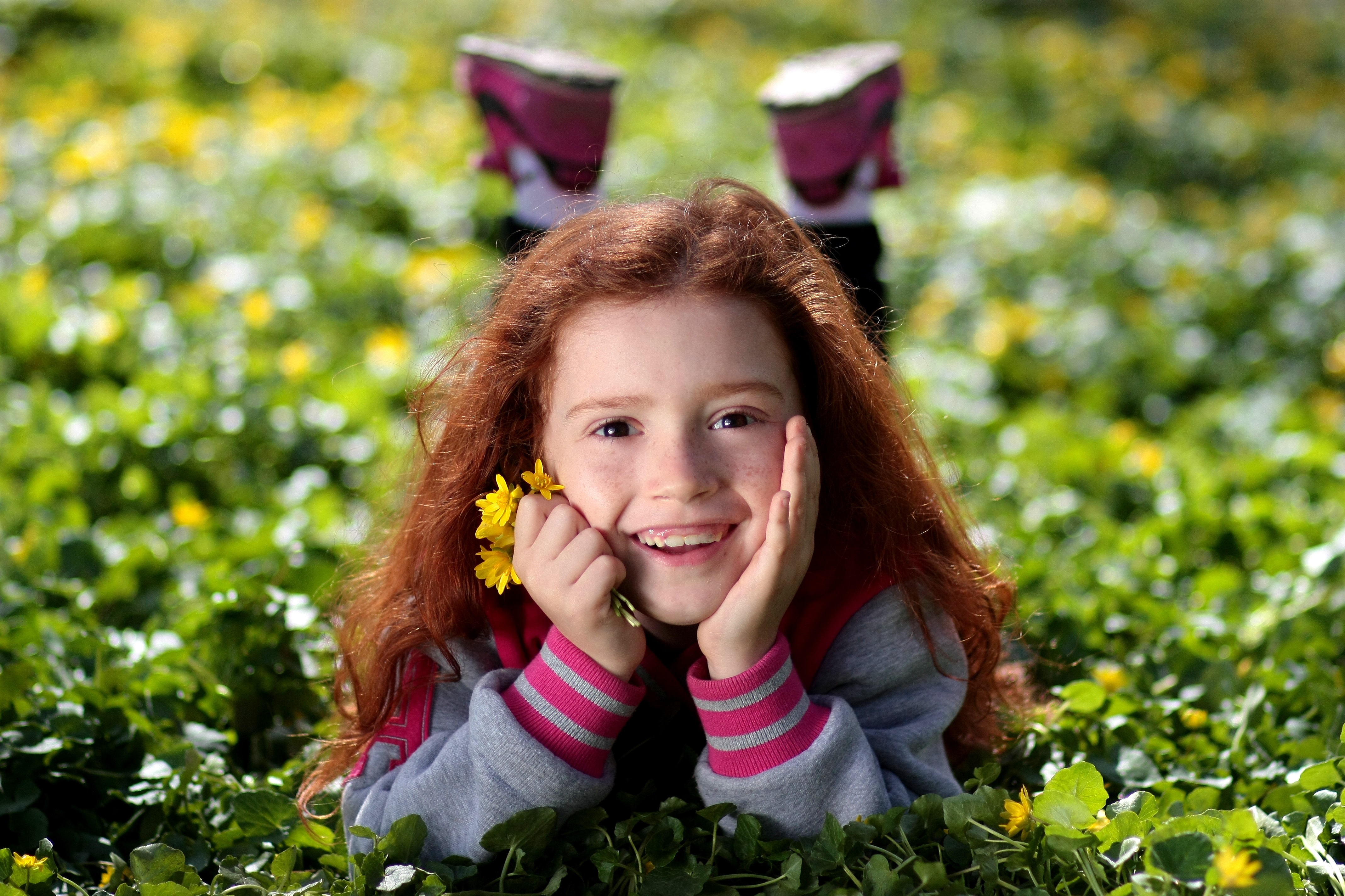 Young girl smiling in a field of flowers.