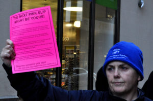 Woman holds up a pink paper. The paper says 